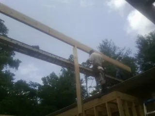 Carpenter setting a ridge beam over a new addition frame — Ice Dam Removal by Roofing Brothers in Mcconnelsville