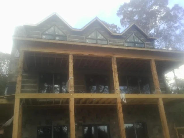 Dormers and porch framing on a large log home under construction — Roof Coating work by our crew in Mcconnelsville