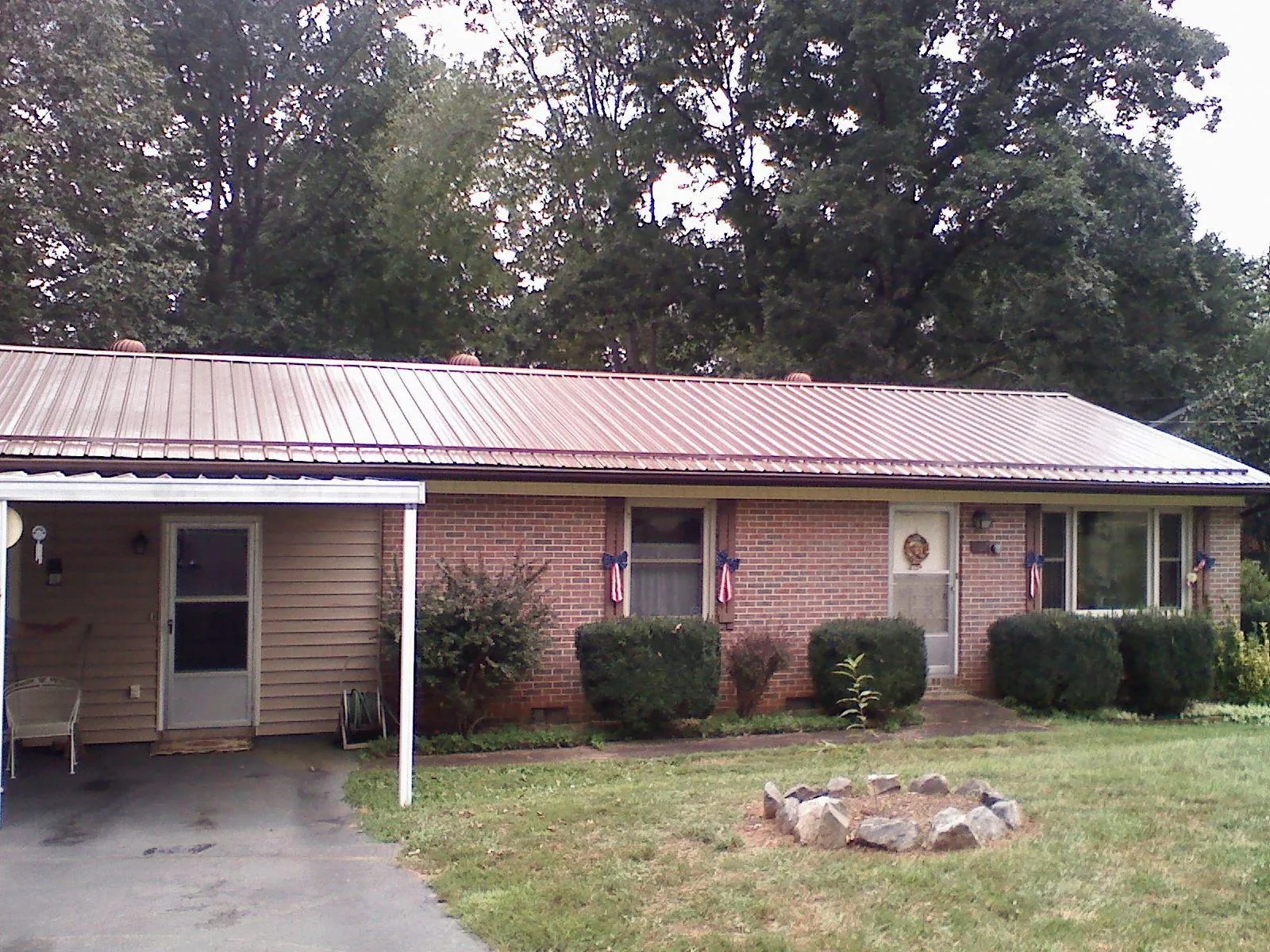 Bronze metal roof and carport on a brick ranch home — Roof Repair work by our crew in Mcconnelsville